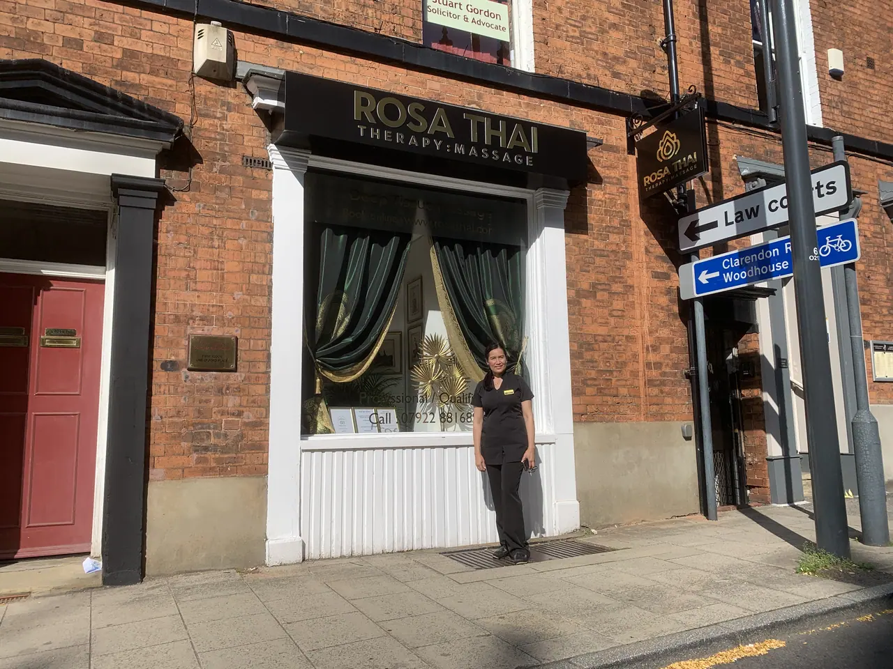 Dark fascia sign with gold lettering above a shop window